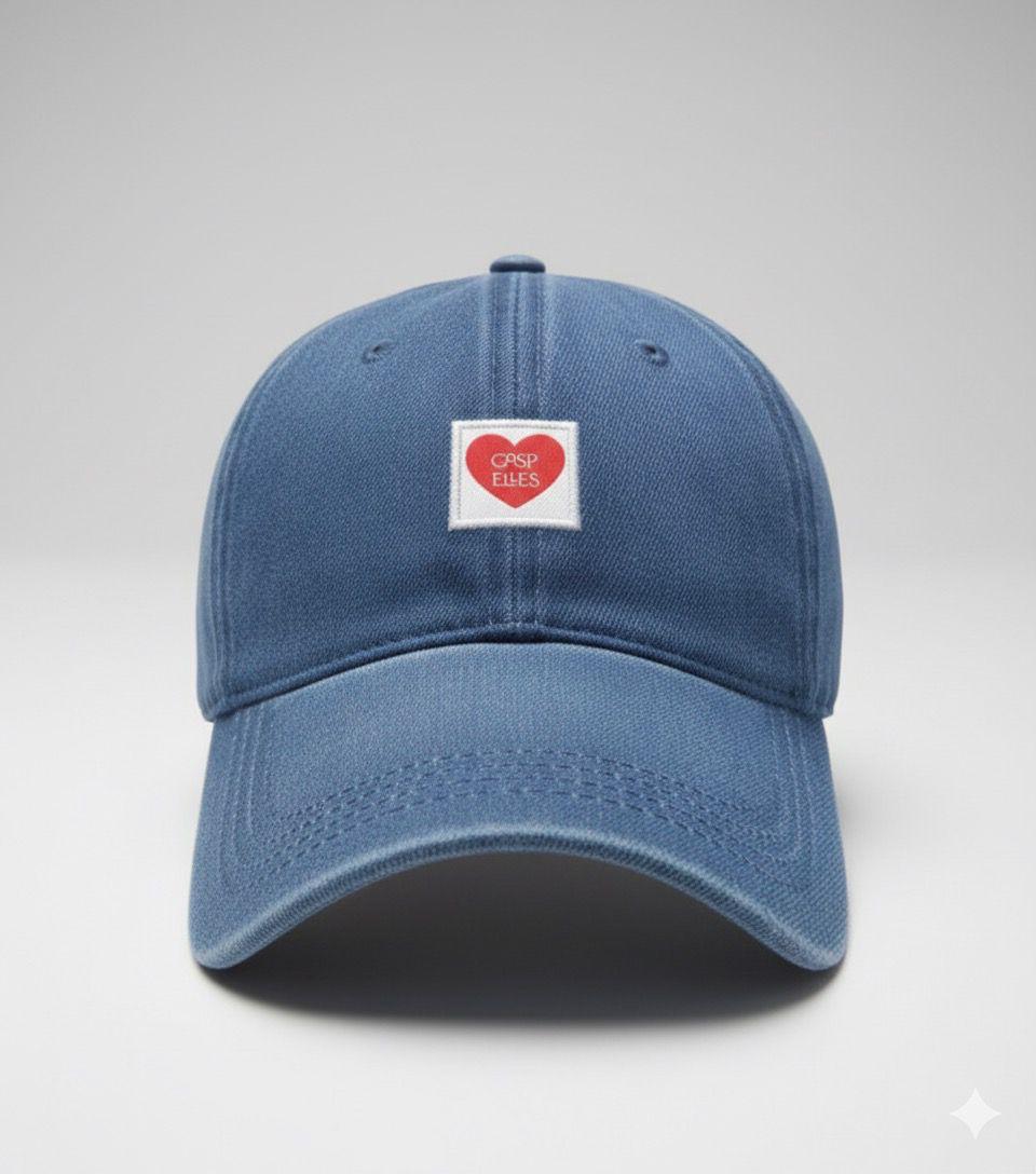 Blue baseball cap with a heart-shaped label on a light gray background
