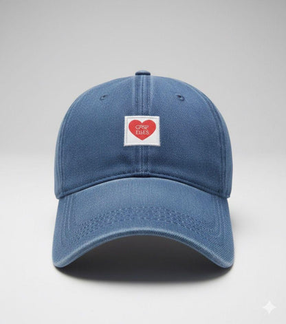 Blue baseball cap with a heart-shaped label on a light gray background