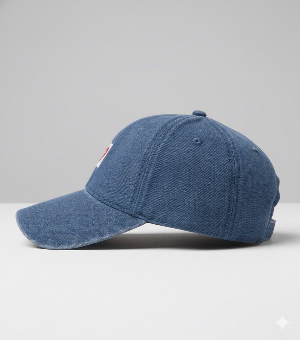 Blue baseball cap with a heart-shaped label on a light gray background